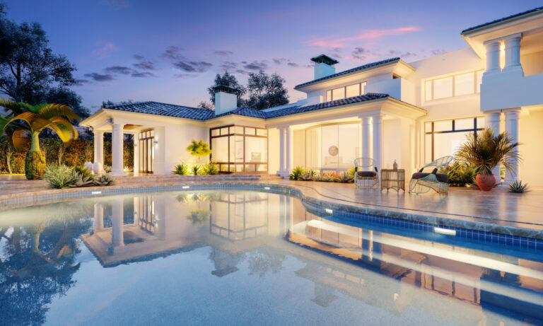 A luxurious modern villa with large windows, surrounded by greenery crafted by a renowned masonry contractor in Suffolk County. The house is illuminated in the evening light, reflecting on a serene swimming pool in the foreground. The sky is a blend of blue and pink hues, suggesting sunset.